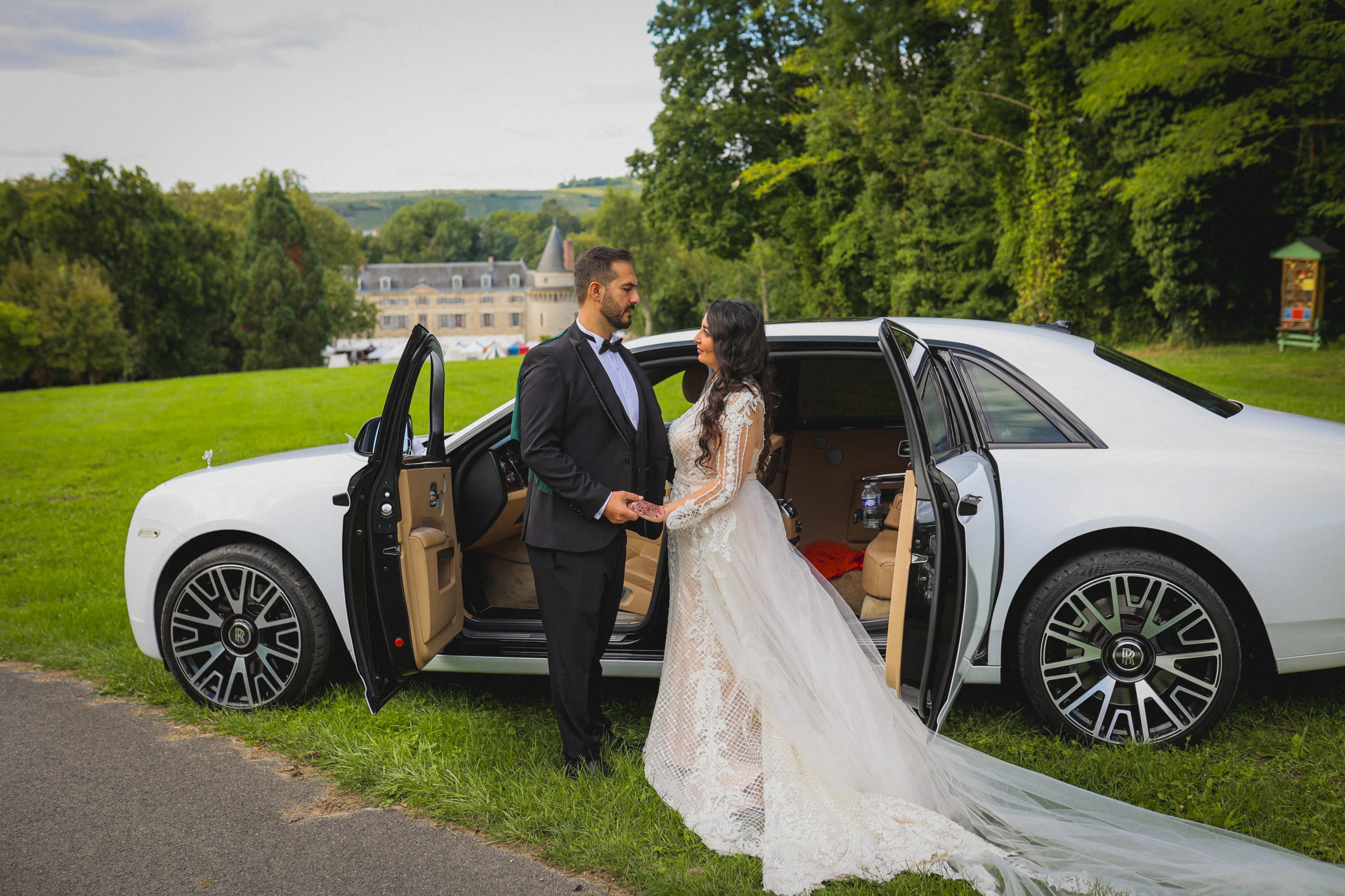 Couple devant une voiture de mariage et un château en Champagne